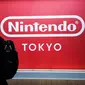 Seorang pria berjalan melewati logo Nintendo Co. Jepang yang dipajang di toko baru Nintendo di Tokyo, 19 November 2019. Nintendo akan meresmikan toko pertamanya di ibu kota Jepang tersebut pada pekan ini. (Behrouz MEHRI/AFP)