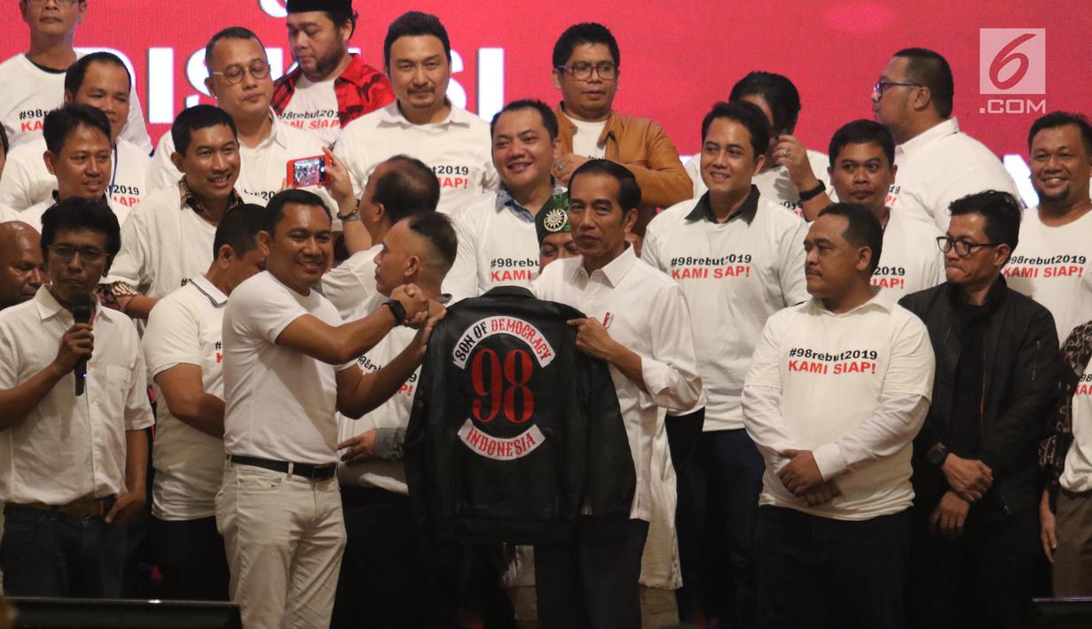 Presiden Joko Widodo menerima jaket bertuliskan Son Of Democracy Indonesia 98 dari aktivis 98 selama acara Halalbihalal di Jakarta, Minggu (16/6/2019). (Liputan6.com/Angga Yuniar)