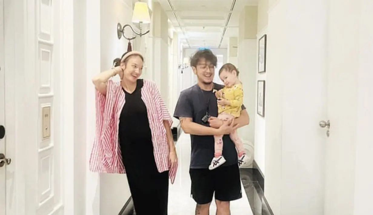 Nadine juga tampil dengan dress panjang hitam dipadukan outer kemeja oversize warna merah bergaris. (@nadinelist)