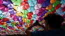 Pengunjung mengambil gambar instalasi Umbrella Sky Project di Aix-en-Provence, Prancis, Jumat (28/6/2019). Spot berteduh yang instagramable tersebut merupakan karya seniman Portugis Patricia Cunha. (BORIS HORVAT/AFP)