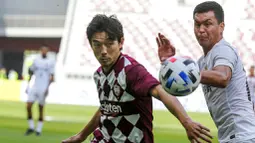 Pemain Shanghai SIPG, Mirahmetjan Muzepper, berebut bola dengan pemain Vissel Kobe, Daigo Nishi, pada laga Liga Champions Asia di Doha, Qatar, Senin (7/12/2/2020). Vissel Kobe menang dengan skor 2-0. (AP Photo/Hussein Sayed)