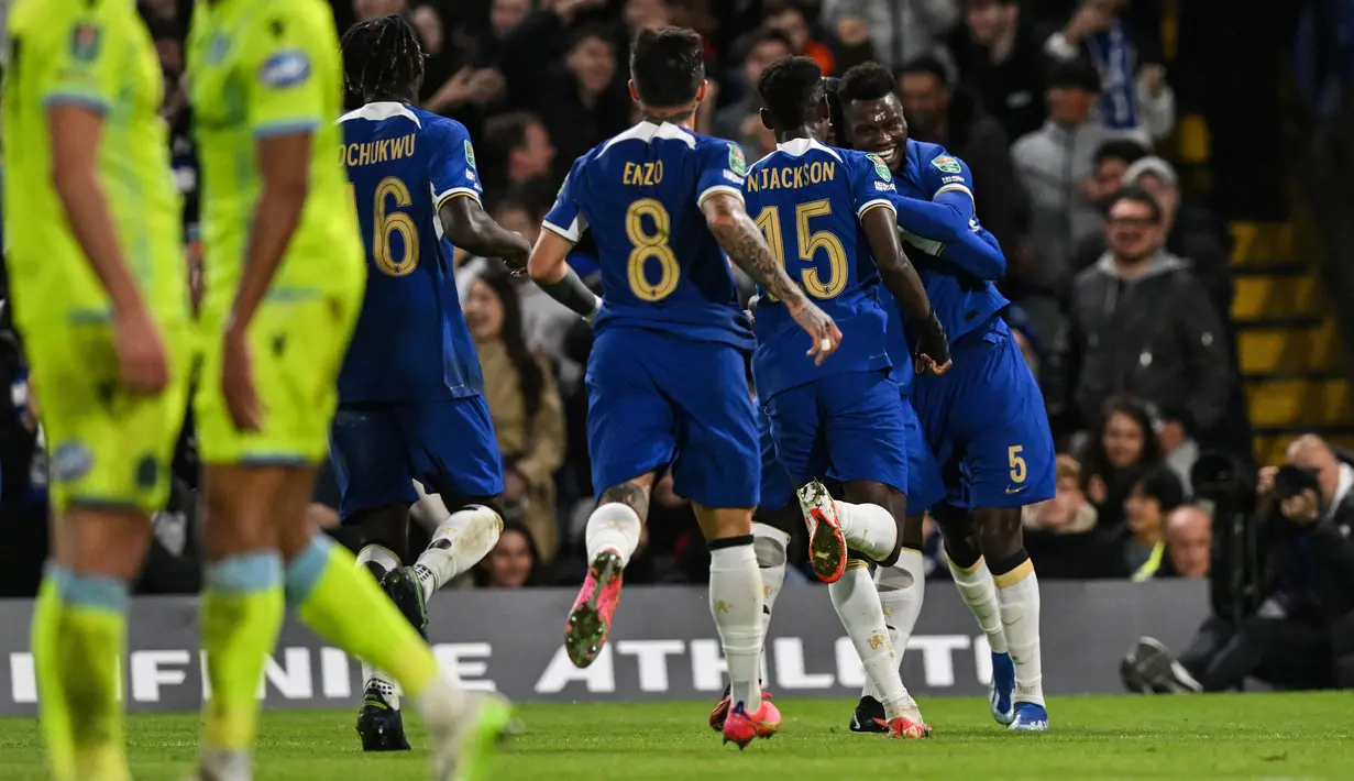 Bek Chelsea #05 Benoit Badiashile (kanan) merayakan bersama rekan satu timnya setelah mencetak gol ke gawang Blackburn Rovers pada laga 16 besar yang berlangsung di Stamford Bridge, Kamis (2/11/2023) dini hari WIB. (Glyn KIRK / AFP)