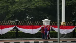 Sejumlah pekerja sibuk memasang kain berwarna merah putih dipagar depan Istana Merdeka Jakarta, Senin (13/4/2015). Jelang Konferensi Asia Afrika (KAA) ke-60 di Bandung pada 24 April mendatang, Istana Merdeka mulai dipercantik. (Liputan6.com/Faizal Fanani)