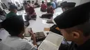 Tradisi ini telah berlangsung lama, tidak hanya bertujuan melancarkan bacaan Al-Quran, tetapi juga memastikan para pelajar atau santri dapat mengkhatamkan Al-Quran selama Ramadan 1447 Hijriah. Tampak dalam foto, para siswa duduk melingkar sambil membaca Al-Quran selama bulan suci Ramadan 1447 Hijriah di Pondok Pesantren Ar-Raudlatul Hasanah di Medan, Sumatera Utara, Sabtu 21 Februari 2026. (AP Photo/Binsar Bakkara)