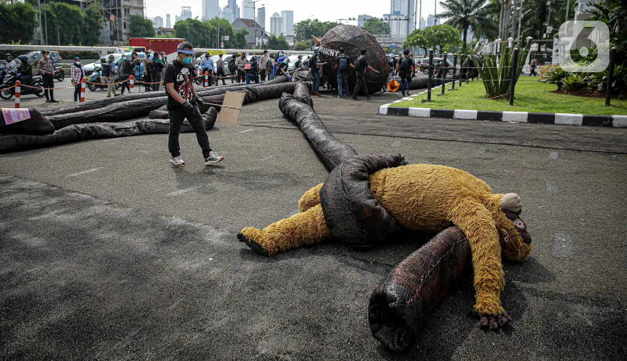 Aktivis Greenpeace saat menggelar aksi di depan Gedung DPR RI, Jakarta, Selasa (5/10/2021). Dalam aksinya, mereka membawa gurita raksasa sebagai simbol oligarki serta menyerukan kepada pemerintah agar serius mengatasi pandemi dan memberantas korupsi energi. (Liputan6.com/Faizal Fanani)
