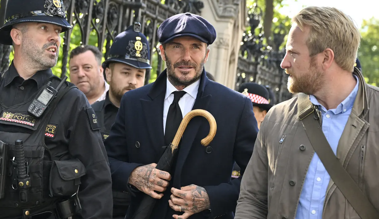 Diketahui, eks kapten Timnas Inggris berusia 47 tahun tersebut telah mengantre sejak pukul 2.15 pagi waktu setempat, dan akhirnya setelah hampir 13 jam David Beckham baru bisa melihat peti mati Ratu Elizabeth II sambil mendoakan sang mendiang pada pukul 15.25 sore. (AFP/Louisa Gouliamaki)