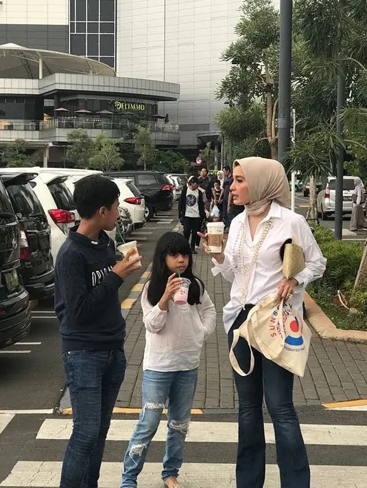 Nah, kalau yangs satu ini sepertinya Arzeti sedang menikmati waktu senggang bersama anak-anaknya. Gayanya sangat kasual dengan celana jeans, kemeja putih dan hijab berwarna cokelat. (Instagram/arzetibi)