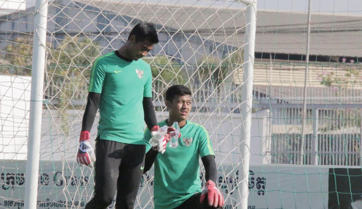 Kiper Timnas Indonesia U-22, Satria Tama dan Muhammad Riyandi, melepas dahaga saat latihan di Lapangan AUPP, Phnom Penh, Selasa (19/2). Latihan ini persiapan jelang laga Piala AFF U-22 melawan Malaysia. (Bola.com/Zulfirdaus Harahap)