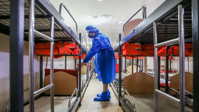 Staf yang mengenakan pakaian pelindung menyiapkan ranjang susun di dalam kapal penumpang yang diubah menjadi fasilitas karantina COVID-19 di Manila, 13 April 2020. Filipina pada Senin (13/4) melaporkan 284 kasus baru COVID-19, sehingga total kasus di negara itu menjadi 4.932. (Xinhua/Rouelle Umali)