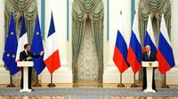 Presiden Rusia Vladimir Putin (kanan) mendengarkan saat konferensi pers bersama Presiden Prancis Emmanuel Macron di Moskow, Rusia, 7 Februari 2022. Emmanuel Macron menemui Vladimir Putin untuk meredakan kebuntuan atas Ukraina. (Thibault Camus/POOL/AFP)
