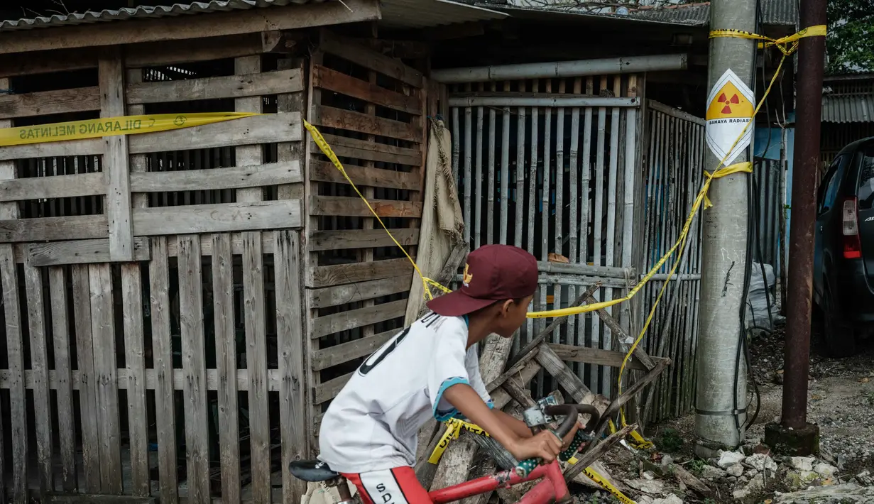 Sebuah stiker peringatan bertuliskan “Bahaya Radiasi” dengan catatan tulisan tangan yang menunjukkan “11,5 mikrosievert per jam” terlihat di salah satu tiang listrik di samping Kawasan Industri Modern Cikande, tempat isotop radioaktif Cesium-137  terdeteksi, di Sukatani, Banten pada 13 Oktober 2025. (Yasuyoshi CHIBA/AFP)