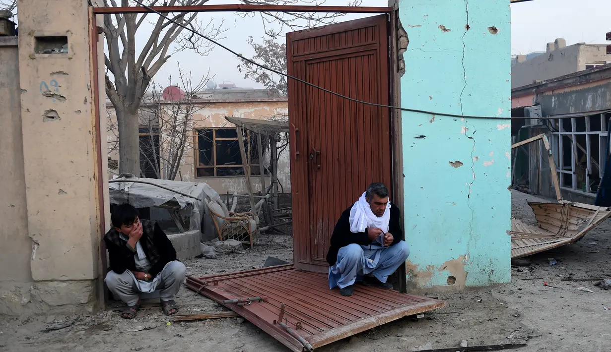 Warga duduk di depan rumah mereka yang rusak di dekat lokasi sebuah bom mobil yang meledak di sebuah restoran Prancis di Kabul, Afganistan, Sabtu (2/1/2016). Akibatnya, dua orang tewas dan 15 lainnya luka-luka. (AFP PHOTO/Wakil Kohsar)