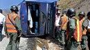 Sejumlah petugas mengamati sebuah bus yang terbalik di jalan raya Caracas-La Guaira, Venezuela, Rabu (10/2). Bus yang mengangkut pemain tim sepak bola Argentina Huracan itu terbalik saat menuju Bandara Internasional Simon Bolivar. (AFP/FEDERICO PARRA)