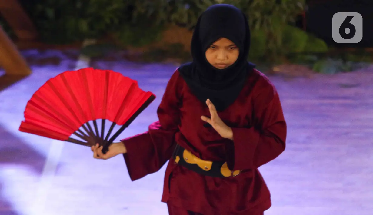 Pesilat melakukan aksi pencak silat saat pentas di Gor Ciracas, Jakarta, Selasa (22/3/2022). Dinas Kebudayaan DKI bersama sejumlah Komunitas Budaya menggelar pergelaran seni budaya untuk memperkenalkan kebudayaan pencak silat serta mengangkat kembali tradisi budaya. (Liputan6.com/Herman Zakharia)