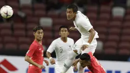 Bek Timnas Indonesia, Hansamu Yama, menyundul bola saat melawan Singapura pada laga Piala AFF di Stadion Nasional, Singapura, Jumat (9/11). Singapura menang 1-0 atas Indonesia. (Bola.com/M. Iqbal Ichsan)