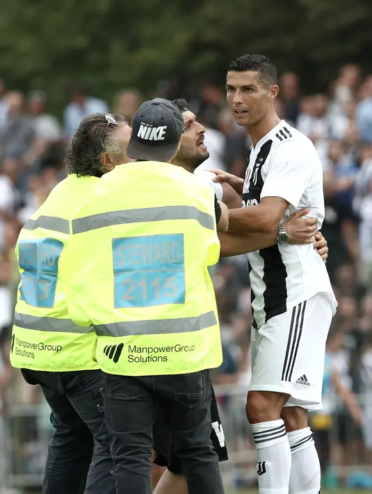 Seorang suporter berusaha memeluk penyerang Juventus, Cristiano Ronaldo selama pertandingan persahabatan antara Juventus A dan tim B, di Villar Perosa, Italia utara, (12/8). Pada pertandingan ini Ronaldo mencetak satu gol. (AFP Photo/Isabella Bonotto)
