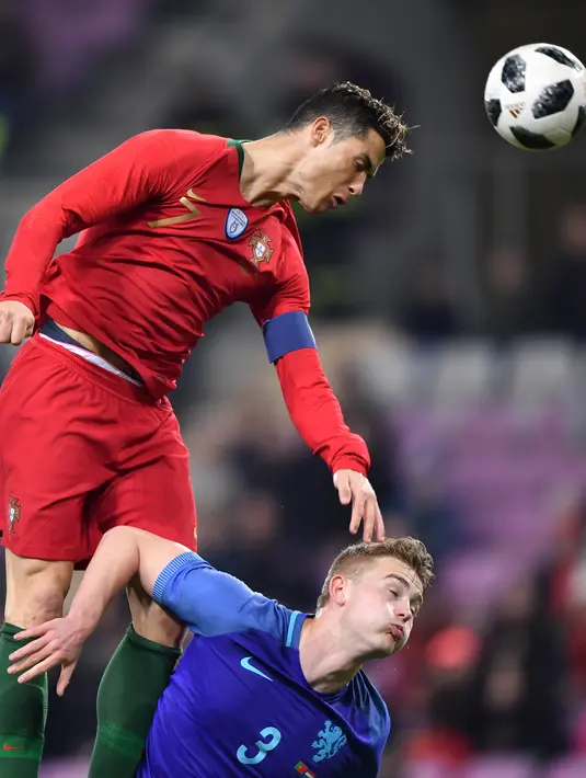 Penyerang Portugal, Cristiano Ronaldo berebut bola dengan bek Belanda, Matthijs de Ligt selama pertandingan persahabatan di stade de Geneve Stadium di Jenewa  pada 26 Maret 2018. Juventus diperkirakan membeli de Ligt senilai 70 juta euro ($ 80 juta) dari Ajax. (AFP Photo/Fabrice Coffrini)