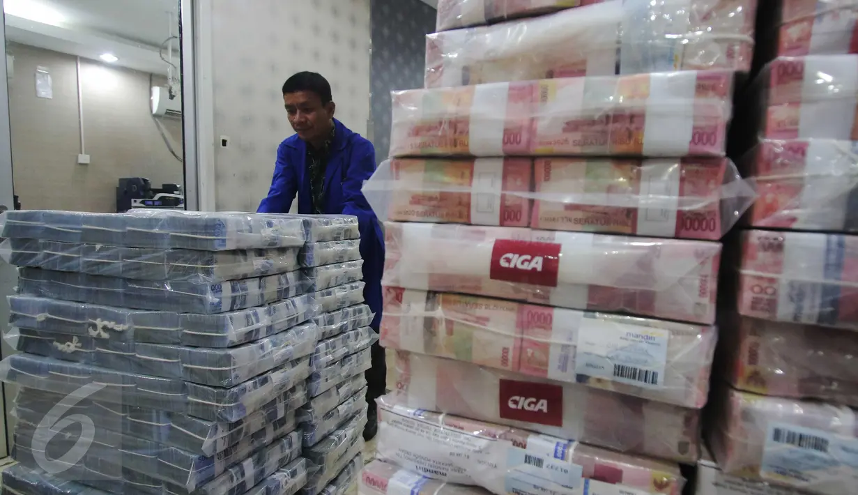 Petugas merapikan uang di Kantor Kas Bank Mandiri, Jakarta, Senin (4/1/2016). Nasib rupiah di tahun 2016 sulit menguat di tengah tingginya permintaan dollar. (Liputan6.com/Angga Yuniar)