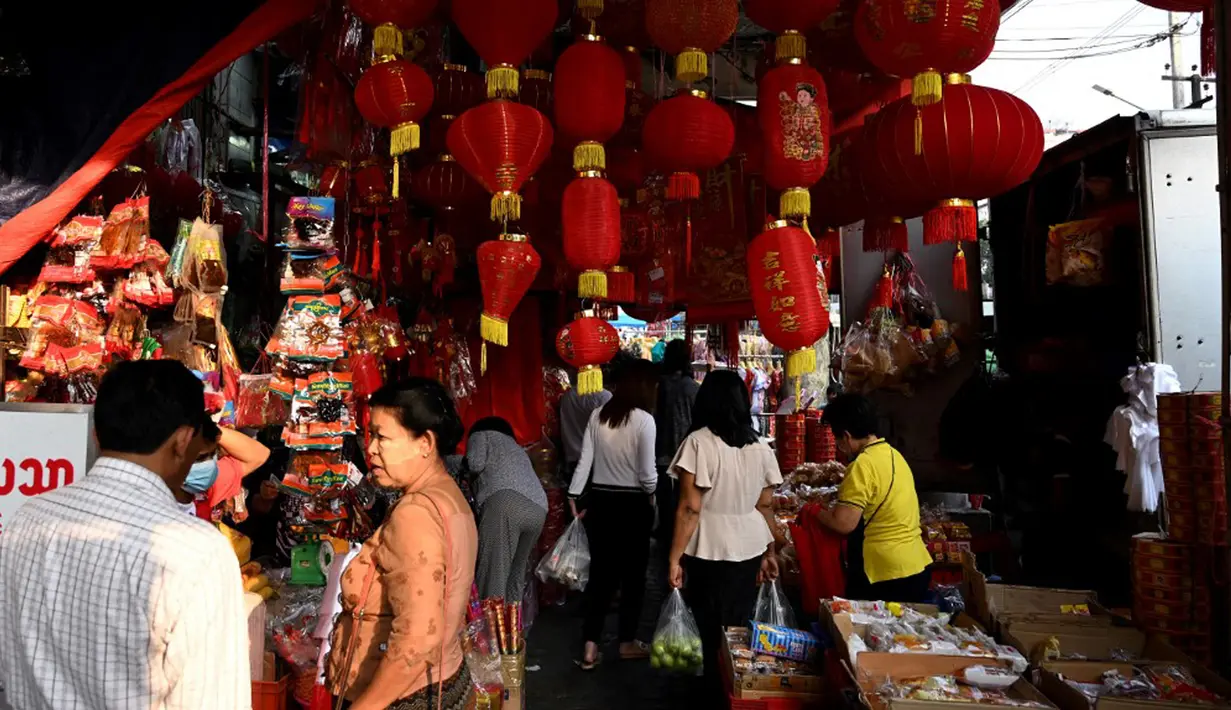 Pelanggan melihat dekorasi di kios pasar jalanan jelang Tahun Baru Imlek di Distrik Pecinan Yangon, Myanmar, 18 Januari 2023. Tahun Baru Imlek 2023 yang disebut sebagai Tahun Kelinci akan jatuh pada tanggal 22 Januari. (STRINGER/AFP)