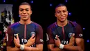 Striker PSG, Kylian Mbappe, berpose dengan patung lilinnya di Museum Grevin, Paris, Kamis (17/5/2018). Patung ini merupakan apresiasi karena keberhasilannya meraih gelar pemain muda terbaik dan trofi Liga Prancis. (AFP/Christophe Simon)