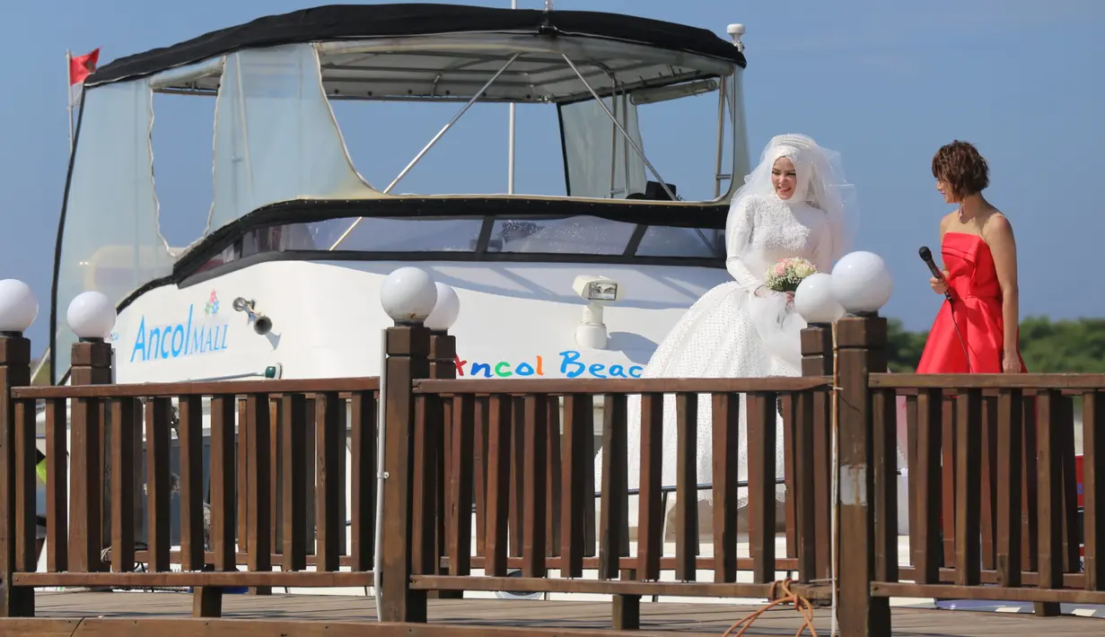 Angel Lelga saat di atas spead boad menunggu sang suami yang melakukan atraksi terjun dari helikopter. Angel tampil cantik dengan balutan gaun warna putih. (Nurwahyunan/Bintang.com)