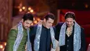 Potret trio menawan sedang berjoget di acara pre-wedding Anant Ambani. Shah Rukh Khan bersama Salman Khan dan Aamir Khan tampil di atas panggung mengenakan baju khas India. Salman memilih warna biru navy, sedangkan Aamir memilih Lungi berwarna hijau yang berkilauan. Ketiganya mengalungkan selendang berpayet biru muda yang berkilauan di bahu mereka. [Foto: Instagram/asianweddingmag]