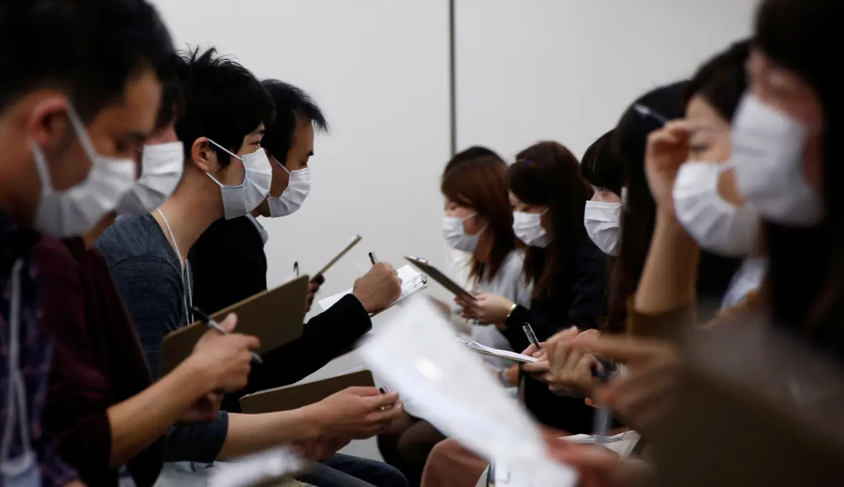 Sejumlah peserta pria dan wanita berbincang saat mengikuti acara layanan kencan di Tokyo, Jepang, (16/10). Peserta diwajibkan menggunakan masker saat memperkenalkan diri satu sama lain. (REUTERS/Kim Kyung-Hoon)