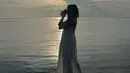 Seluruh keindahan alam dirasakan Gisella Anastasia saat liburan, termasuk matahari terbenam. Berlatar laut dan matahari yang hendak terbenam, Gisel mengenakan dress menerawang berwarna putih. Potret yang nyaris siluet ini menampilkan sosok Gisel yang sedang membidik objek dengan kamera.