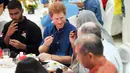 Pangeran Harry ikut berbuka puasa bersama dengan komunitas muslim saat mengunjungi Jamiyah Children's Home di Singapura, Minggu (4/6). Pangeran Harry melakukan kunjungan dua hari di Singapura untuk ambil bagian dalam acara amal. (JOSEPH NAIR / POOL / AFP)