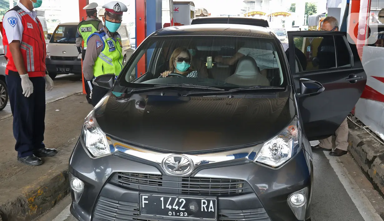 Petugas memeriksa kendaraan yang memasuki Jakarta pada penerapan PSBB di gerbang pintu Tol Pasar Rebo 2, Jakarta, Jumat (10/4/2020). Petugas kepolisian mengimbau kepada seluruh pengendara dan penumpang agar mengenakan masker. (Liputan6.com/Herman Zakharia)