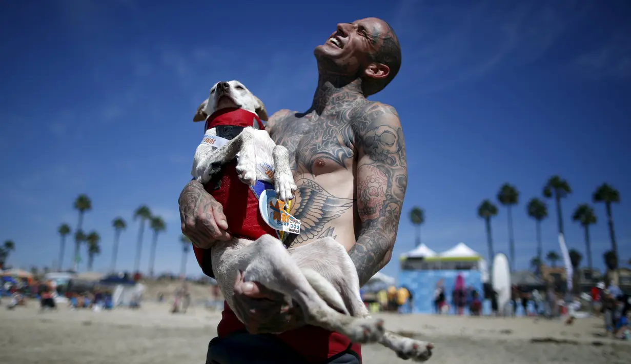 Ryan Rustan tertawa bersama anjingnya usai berlaga di Surf Dog Contest Surf City di Huntington Beach, California, Amerika Serikat, (27/9/2015). (REUTERS/Lucy Nicholson)