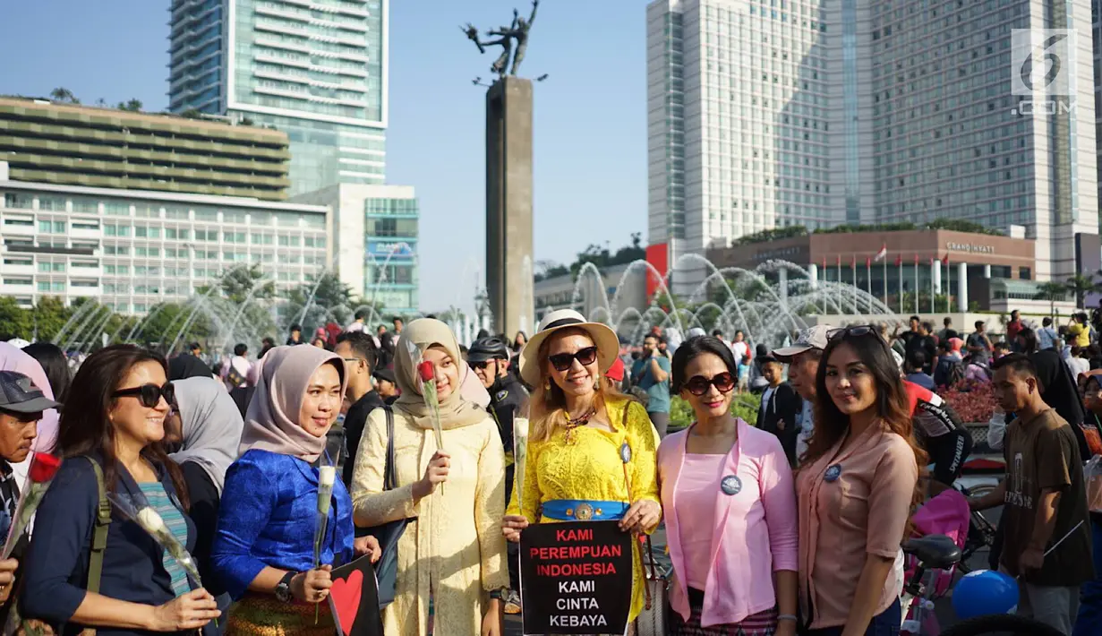 Relawan memegang bunga mawar untuk dibagikan ke pengunjung car free day di kawasan Bundaran HI, Jakarta, Minggu (30/6/2019).  Aksi 1000 bunga mawar itu sebagai bentuk rasa syukur atas kemenangan pasangan Jokowi-Ma'ruf Amin di Pilpres 2019. (Liputan6.com/Immanuel Antonius)