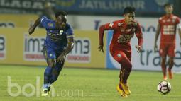 Gelandang Persib Bandung, Michael Essien dan Gelandang Arema FC, Hanif Sjahbani berusaha mengejar bola. Dalam pertandingan tersebut, Essien turun sebagai starter hingga digantikan Dedi Kusnandar di pertengahan babak kedua. (Bola.com/M Iqbal Ichsan).