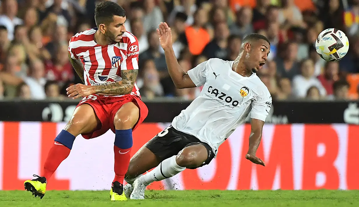 Penyerang  Atletico Madrid, Angel Correa (kiri) berebut bola dengan penyerang Valencia, Samuel Lino selama pertandingan lanjutan La Liga Spanyol di stadion Mestalla di Valencia (30/8/2022). Atletico Madrid menang tipis atas tuan rumah Valencia 1-0. (AFP/Jose Jordan)