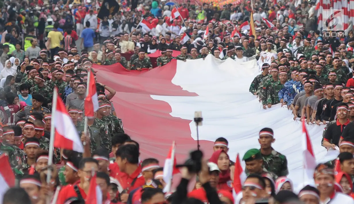 Anggota TNI POLRI  bersama warga masyarakat membawa bendera raksasa berukuran panjang 117 meter dan lebar 5 meter saat gelaran Festival Merah-Putih (FMP) 2018 di kawasan Air Mancur, Bogor ,  Minggu (5/8). (Merdeka.com/Arie Basuki)