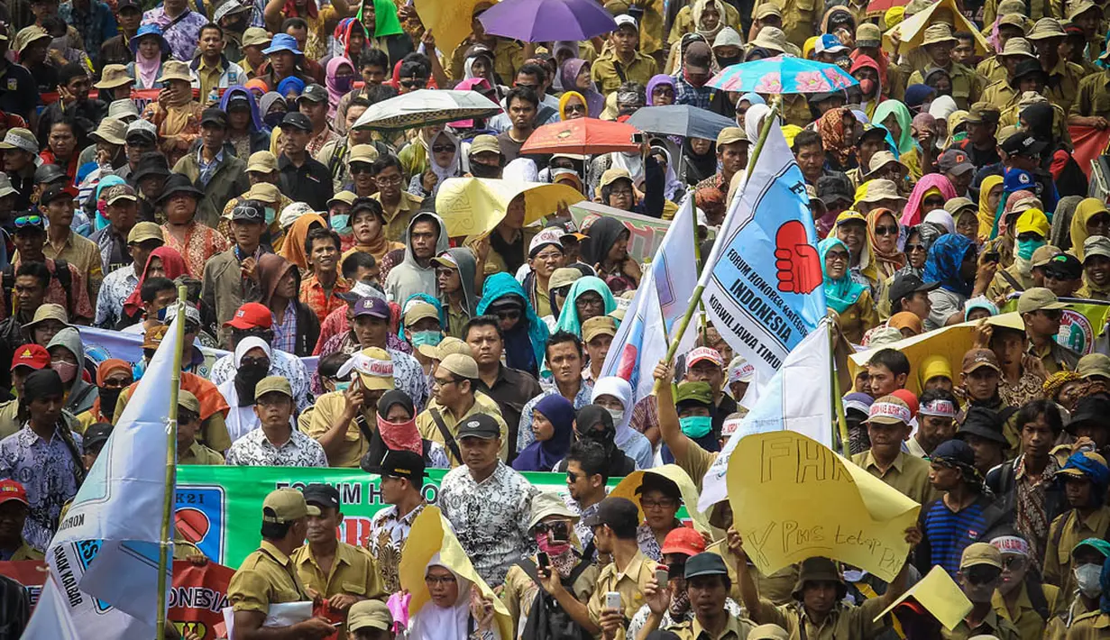 Ribuan pegawai honorer menggelar aksi longmarch dari patung kuda menuju Istana Negara, Jakarta, (15/10/14). (Liputan6.com/Faizal Fanani)