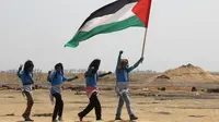 Warga Palestina bergaya seperti karakter dari film "Avatar" mengibarkan bendera selama protes menuntut hak untuk kembali ke kampung halaman mereka di perbatasan Israel-Gaza, Timur Khan Yunis di Gaza selatan Strip, (4/5). (AFP Photo/Said Khatib)