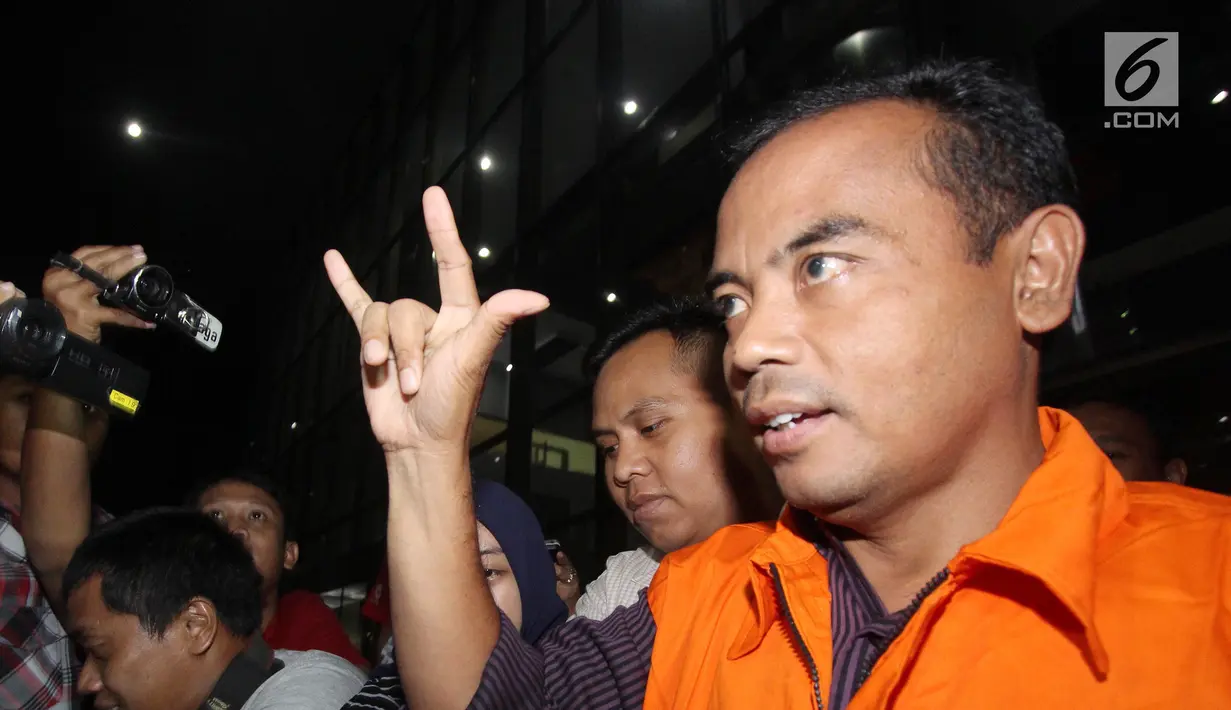 Tersangka Bupati Purbalingga, Tasdi kenakan rompi oranye sambil salam metal usai pemeriksaan di Gedung KPK, Jakarta, Selasa (5/6). Bupati Tasdi diduga menerima uang Rp 100 juta dari pemenang proyek pembangunan tahap dua. (Liputan6.com/Herman Zakharia)
