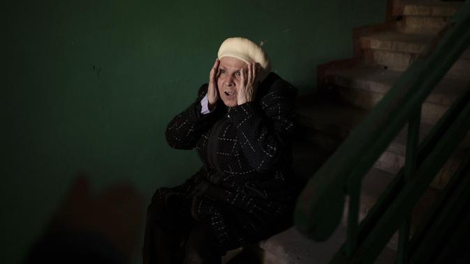<p>Seorang wanita tua di Ukraina terlihat kaget. Ia bereaksi demikian saat ada mayat anak laki-laki berusia 15 tahun di dekatnya. Dok: AP Photo/Felipe Dana</p>