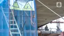 Aktivitas pekerja saat menyelesaikan proyek pembangunan jalur lintas atas (flyover) Cakung, Jakarta, Kamis (17/12/2020). Proyek Flyover Cakung saat ini telah mencapai 94 persen dan sedang menyelesaikan pemasangan balok girder pada bentang yang melintasi rel kereta api. (merdeka.com/Iqbal Nugroho)