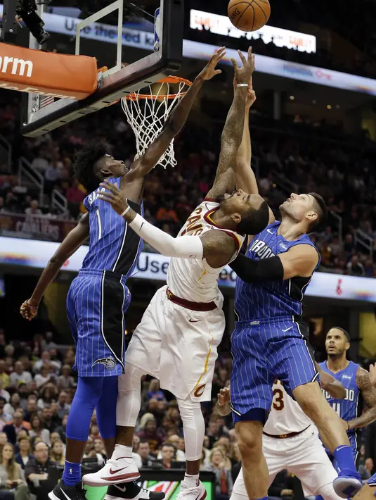 Pebasket Orlando Magic, Jonathan Isaac dan Nikola Vucevic, memghalau pebasket Cleveland Cavaliers, JR Smith, pada laga NBA di Quicken Loans Arena, Ohio, Sabtu (21/10/2017). Cleveland Cavaliers kalah 93-114 dari Orlando Magic. (AP Photo/Tony Dejak)