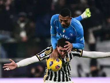 Pemain Juventus, Dusan Vlahovic (bawah), berebut bola dengan pemain Napoli, Juan Jesus, dalam pertandingan pekan ke-15 Liga Italia 2023/2024 yang berlangsung di Allianz Stadium, Sabtu (9/12/2023) dini hari WIB. (AFP/Marco Bertorello)