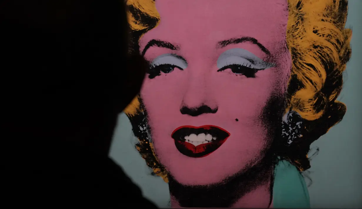 Lukisan "Shot Sage Blue Marilyn" karya Andy Warhol ditampilkan selama pratinjau pers di New York, Senin (21/3/2022). Rumah lelang Christie akan melelang lukisan potret Marilyn Monroe tersebut yang diperkirakan akan laku dengan harga US$200 juta atau sekira Rp2,8 triliun. (TIMOTHY A. CLARY/AFP)