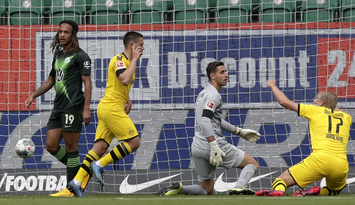 Pemain Borussia Dortmund, Raphael Guerreiro, melakukan selebrasi usai membobol gawang Wolfsburg pada laga Bundesliga, Minggu (24/5/2020). Borussia Dortmund menang 2-0 atas Wolfsburg. (AP/Michael Sohn)