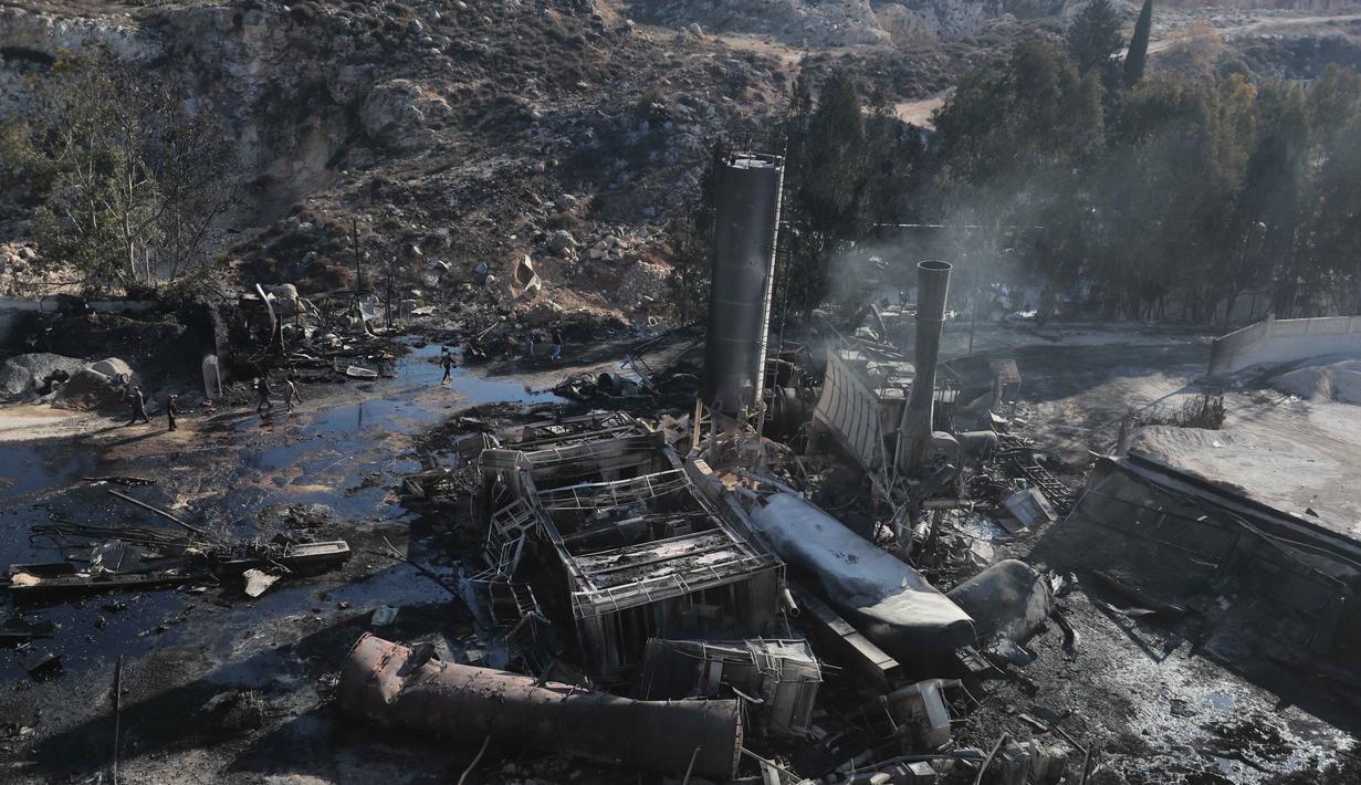 Orang-orang memeriksa kerusakan di pabrik semen yang disebabkan oleh serangan udara Israel di desa Ansar, Lebanon Selatan, pada Jumat 17 Oktober 2025. (AP Photo/Mohammad Zaatari)