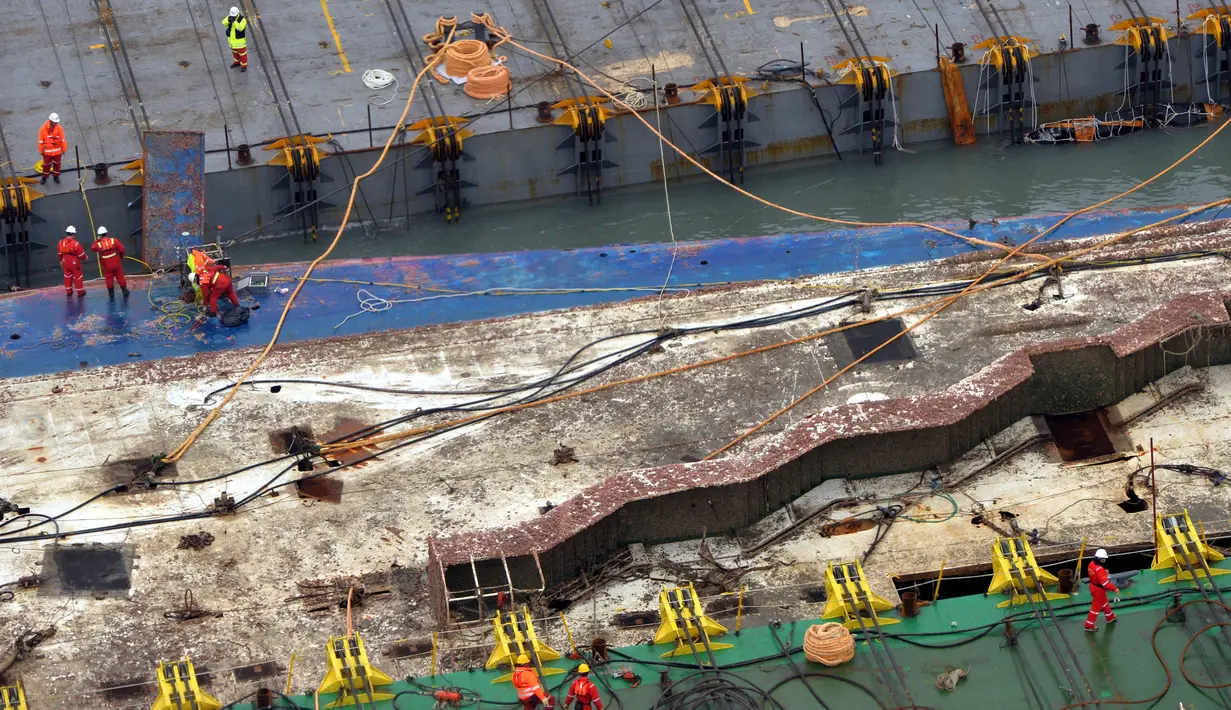 Pekerja mempersiapkan diri mengangkat bangkai kapal feri Sewol di pulau barat daya Jindo, Korea Selatan, Kamis (23/3). Operasi pengangkatan feri sewol menjadi tuntutan utama keluarga 9 korban yang masih dinyatakan hilang. (Park Gyung-woo/Hankookilbo/AP)