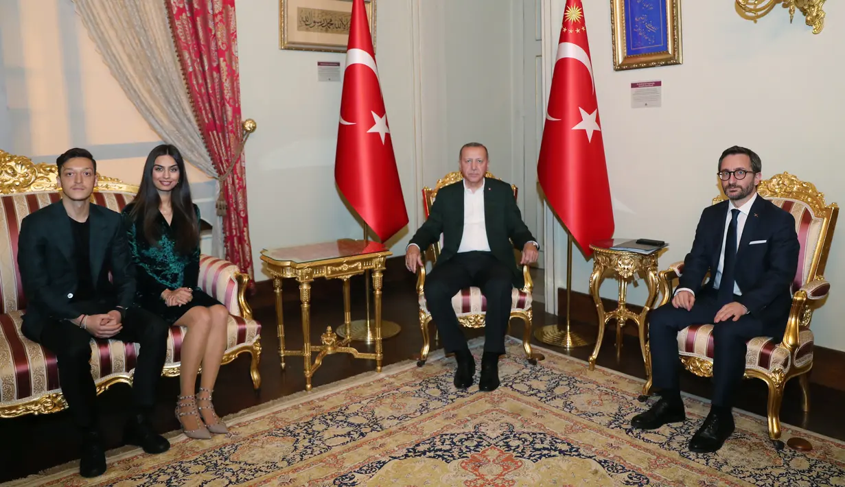 Gelandang Arsenal, Mesut Ozil didampingi kekasihnya Amine Gulse berbicang dengan Presiden Turki Recep Tayyip Erdogan saat menghadiri acara buka puasa bersama di Istana Dolmabahce, Istanbul, Turki (19/5). (Stringer/Turkish President's Press Office/AFP)