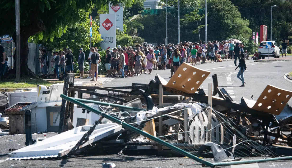 Selain membakar dan menjarah toko-toko, perusuh juga membuat barikade jalan hingga memutus akses terhadap obat-obatan dan makanan. (Delphine Mayeur/AFP)