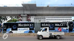 Sebuah mobil melintas di sebelah bus Transjakarta di Terminal Blok M, Jakarta Selatan, Kamis (12/1). PT Transjakarta tambah 2.000 unit bus, sehingga pada akhir tahun 2017 jumlah bus yang dimiliki bisa mencapai 3.300 unit. (Liputan6.com/Gempur M. Surya)