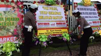 Sejumlah pesan moral juga disampaikan dalam karangan bunga yang dikirim ke Mapolda Papua. (Liputan6.com/Katharina Janur)